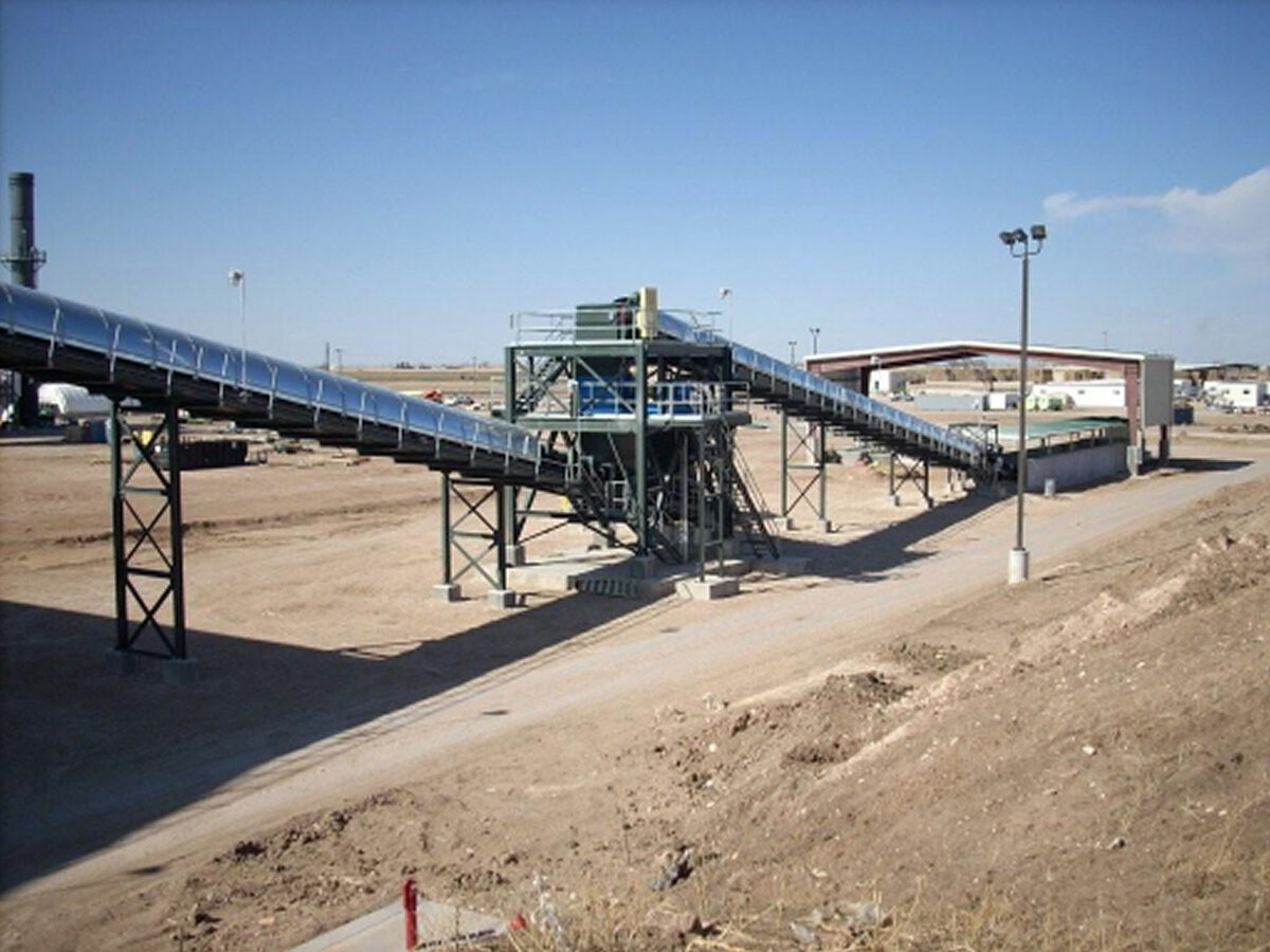 Inclined Orthman belt conveyors on steel truss supports at an outdoor bulk material handling site