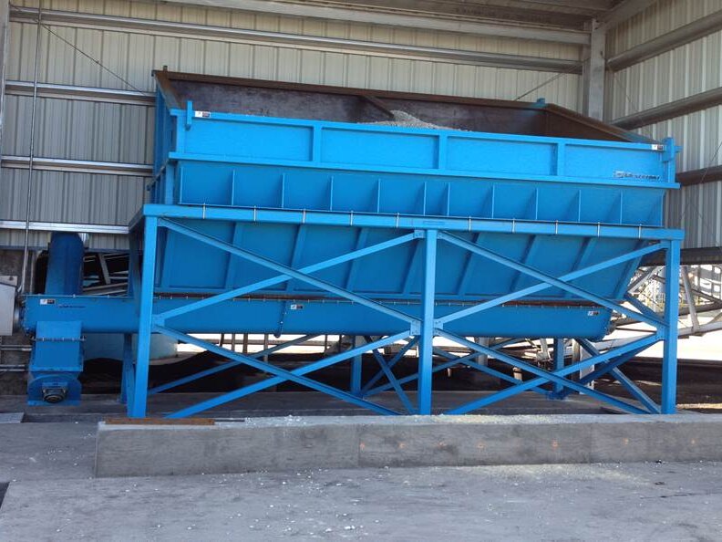 Blue Orthman hopper on a cross-braced steel support frame, installed under a building canopy
