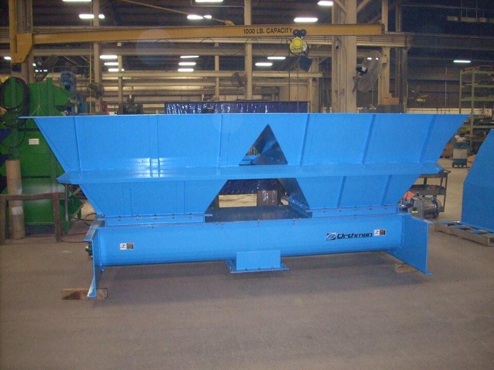 Orthman hopper mounted over an integrated screw feeder in the Cleburne, Texas shop